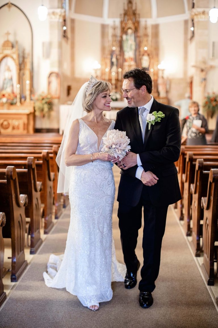 Newly married couple walking down aisle in a church.